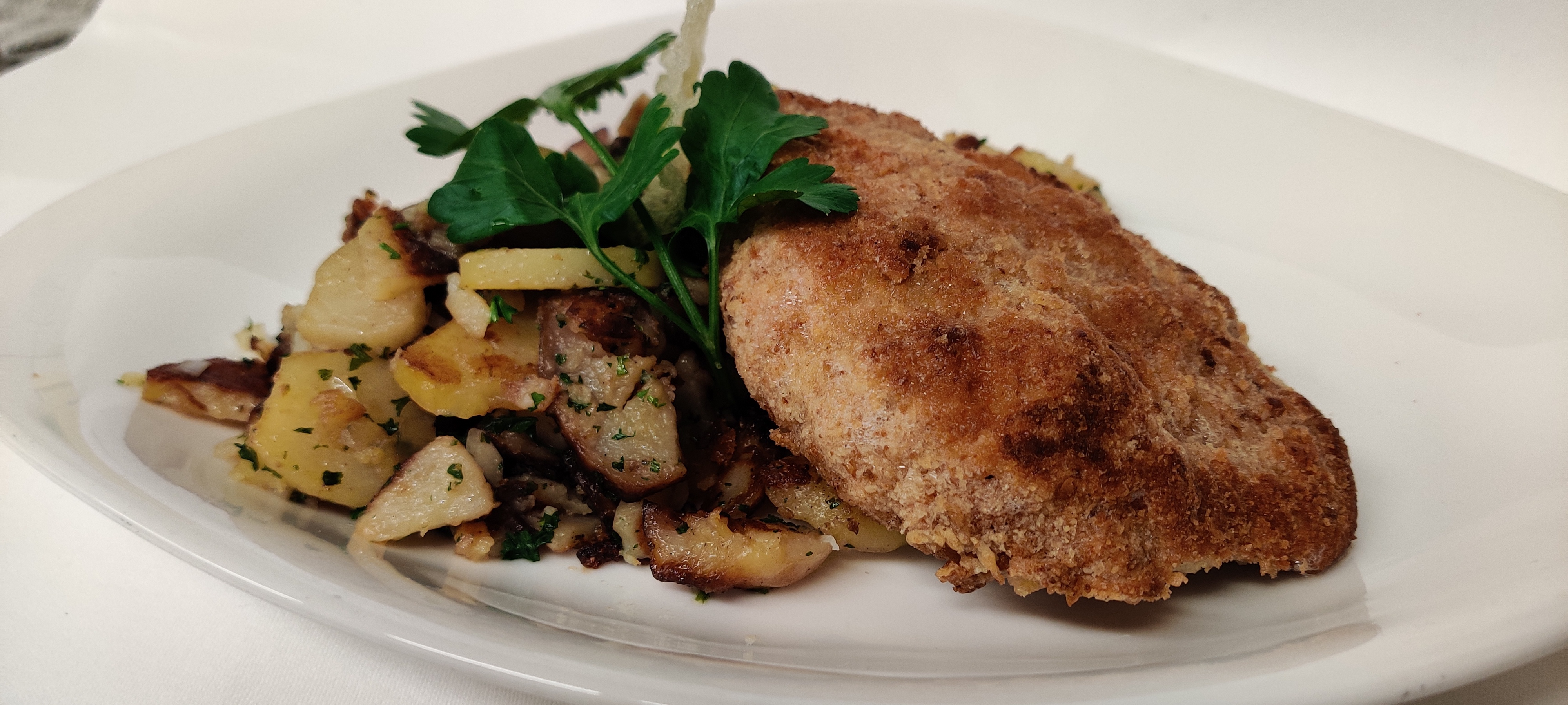 Grünewalds_cordon_bleu_in_bauernbrotpanade_gefuellt_mit_huettenthaler_handkaese_und_schinken mit Bratkartoffeln