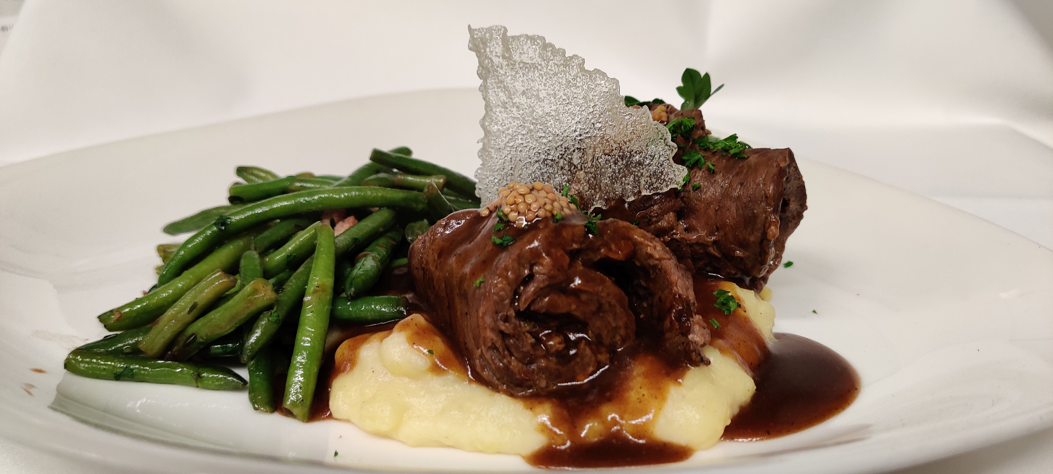 Grünewalds geschmorte_rinderroulade_mit_senfkaviar mit Kartoffelpürree und Speckbohnen